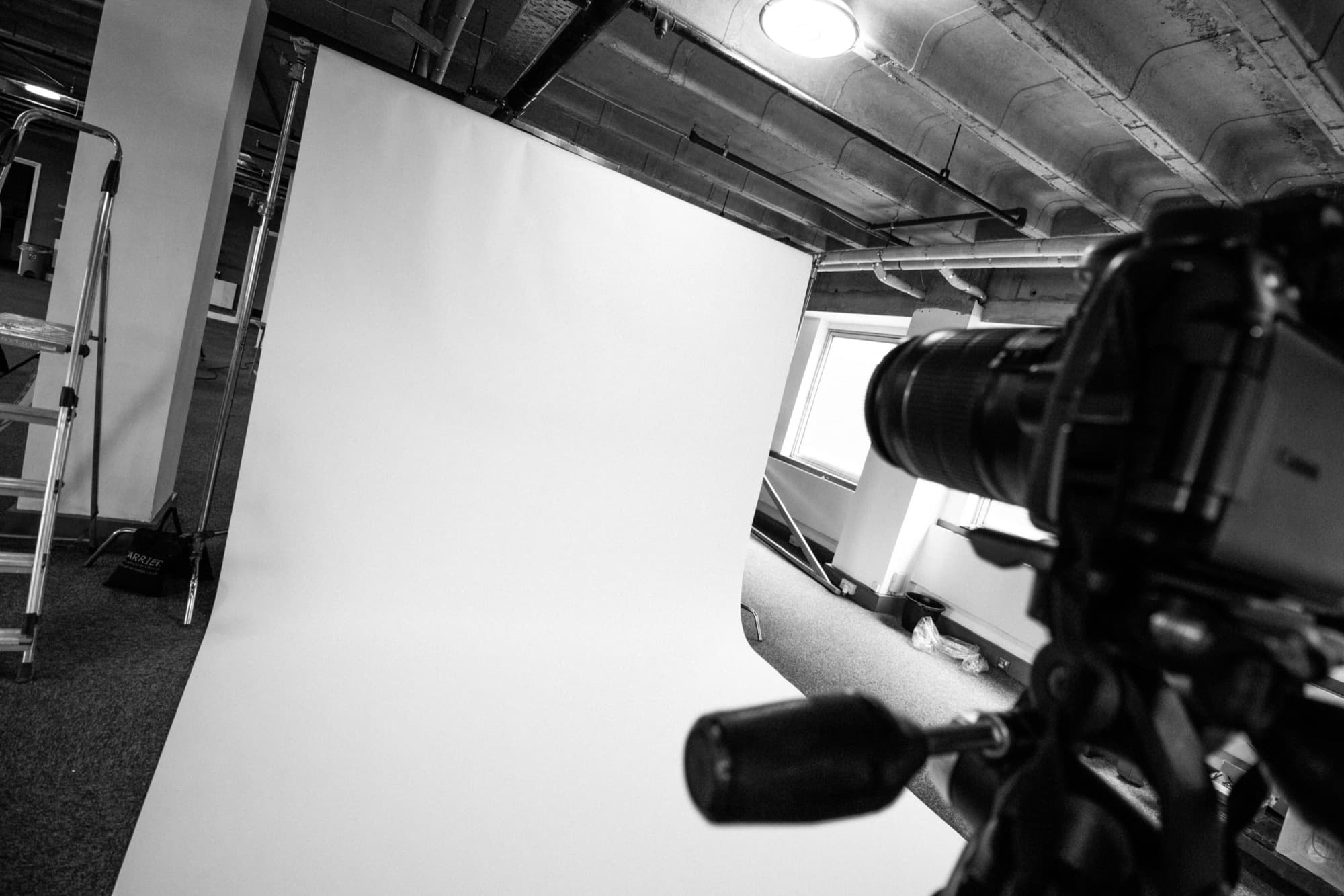 A camera pointed at a white cyclorama backdrop in the studio